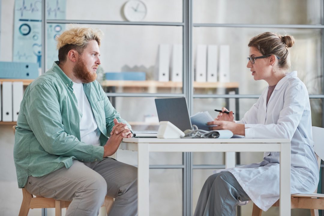 man-talking-to-the-doctor-at-office